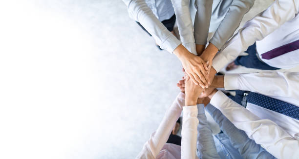 Stack of hands. Unity and teamwork concept. Close up top view of young business people putting their hands together. Stack of hands. Unity and teamwork concept. project experts stock pictures, royalty-free photos & images